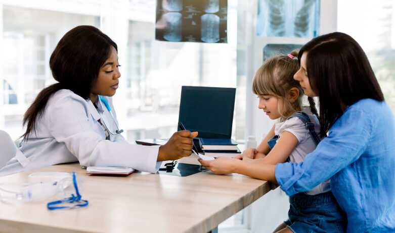 a doctor speaking with a mother and daughter