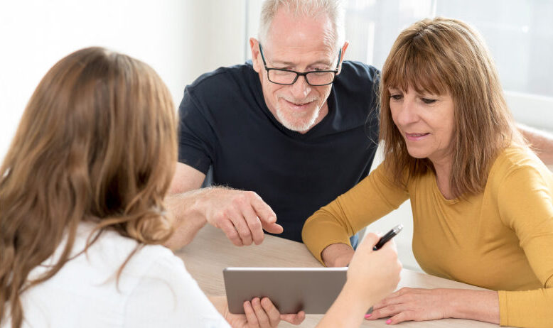 retirement age couple reviewing documents with a lawyer