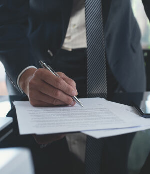 lawyer signing papers on a desk