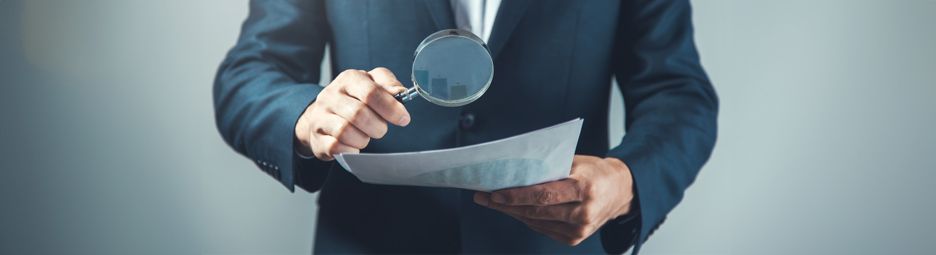 man hand magnifier and document on the grey background